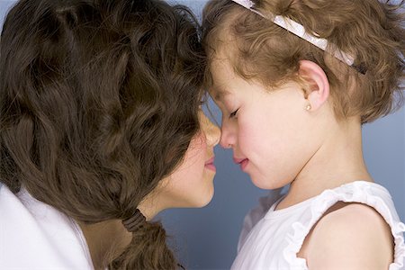 Side profile of two sisters rubbing their noses Stock Photo - Premium Royalty-Free, Code: 640-01358174