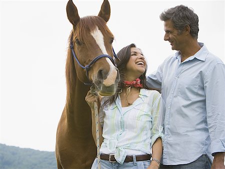 woman holding the reins of a horse with a man beside her Stock Photo - Premium Royalty-Free, Code: 640-01358259