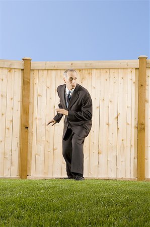 Low angle view of a businessman standing in front of a wall Stock Photo - Premium Royalty-Free, Code: 640-01358302
