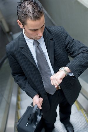 simsearch:640-01350815,k - High angle view of a businessman looking at his wristwatch on an escalator Stock Photo - Premium Royalty-Free, Code: 640-01358322
