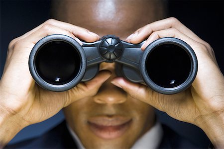 Man looking through binoculars Stock Photo - Premium Royalty-Free, Code: 640-01358369