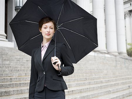 simsearch:640-02767805,k - Portrait of a female lawyer standing on the steps of a courthouse and holding an umbrella Stock Photo - Premium Royalty-Free, Code: 640-01358486