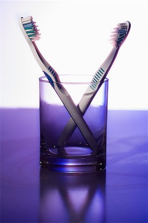 Close-up of two toothbrushes in a glass Stock Photo - Premium Royalty-Free, Code: 640-01358507