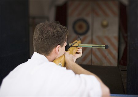 propulsion - Rear view of a young man target shooting Stock Photo - Premium Royalty-Free, Code: 640-01358898