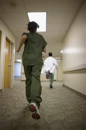 simsearch:632-01613036,k - Young female nurse running behind a young male doctor Stock Photo - Premium Royalty-Free, Code: 640-01359031