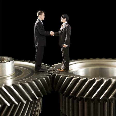 simsearch:640-03262464,k - Two businessmen standing on cogs shaking hands Stock Photo - Premium Royalty-Free, Code: 640-01359075