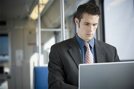 Young businessman using a laptop Stock Photo - Premium Royalty-Free, Code: 640-01359170