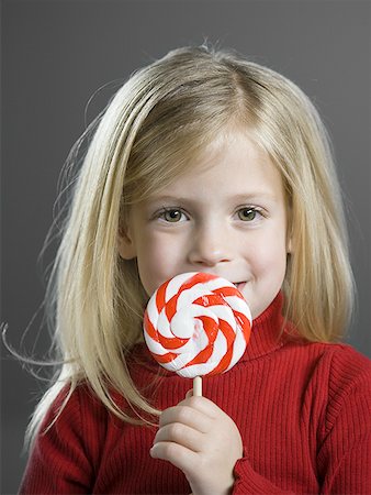 Portrait of a girl holding a lollipop Stock Photo - Premium Royalty-Free, Code: 640-01359754
