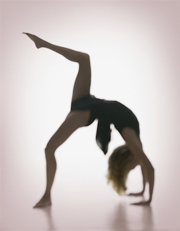 silhouette of woman bending backwards - Side profile of a young woman bending over backwards Stock Photo - Premium Royalty-Free, Code: 640-01359854