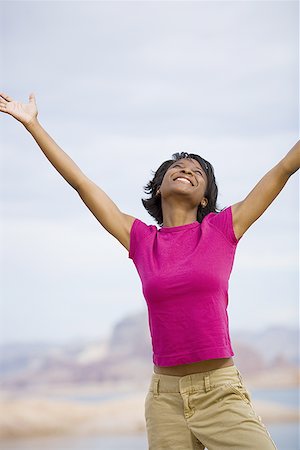 energetic young black people - Young woman standing with arm raised Stock Photo - Premium Royalty-Free, Code: 640-01350095