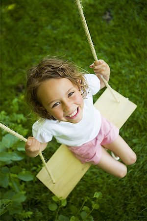 High angle view of a girl sitting on a swing Stock Photo - Premium Royalty-Free, Code: 640-01350092