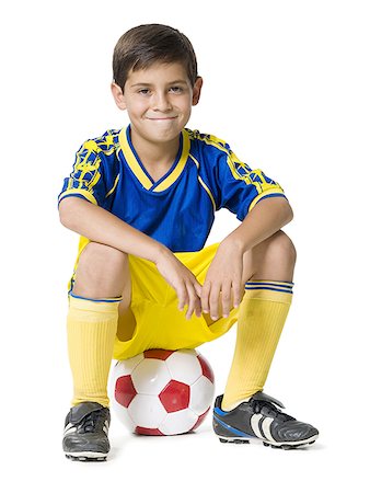 Portrait d'un garçon assis sur un ballon de soccer Photographie de stock - Premium Libres de Droits, Code: 640-01350232