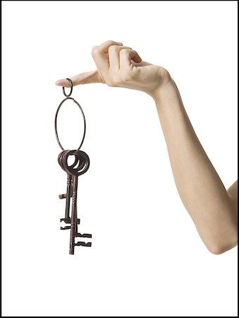 Close-up of a key ring hanging from a finger Stock Photo - Premium Royalty-Free, Code: 640-01350400