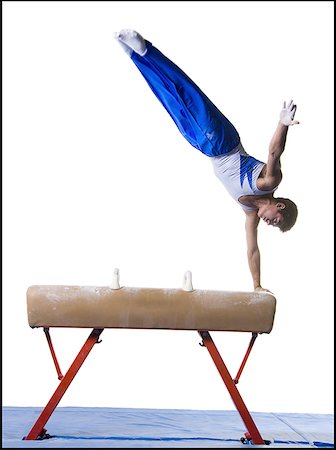 Male gymnast performing routines on vaulting horse Stock Photo - Premium Royalty-Free, Code: 640-01350412