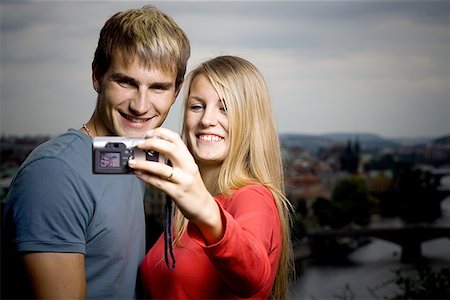 Close-up of a young man and a young woman photographing themselves Stock Photo - Premium Royalty-Free, Code: 640-01350518