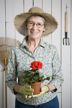 simsearch:640-02768330,k - Portrait of an elderly woman holding a potted plant Stock Photo - Premium Royalty-Free, Code: 640-01350754