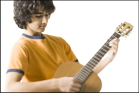 Close-up of a teenage boy playing the guitar Stock Photo - Premium Royalty-Free, Code: 640-01351116