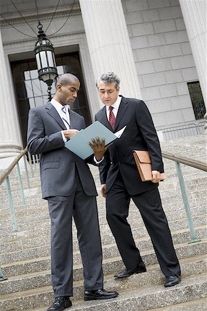 simsearch:640-01351636,k - Low angle view of two men looking at documents on the steps of a courthouse Stock Photo - Premium Royalty-Free, Code: 640-01351216