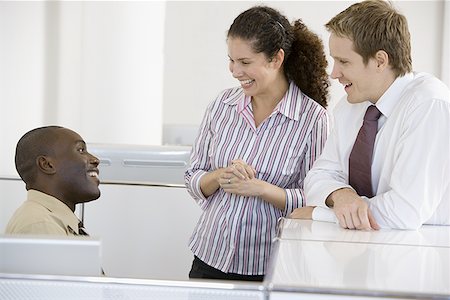 Three co-workers talking in an office Stock Photo - Premium Royalty-Free, Code: 640-01351240