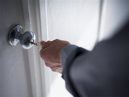 Close-up of a person's hand opening a door lock with a key Foto de stock - Sin royalties Premium, Código: 640-01351273