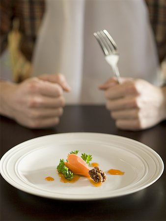 Close-up of food in a plate with a person holding a fork Stock Photo - Premium Royalty-Free, Code: 640-01351356