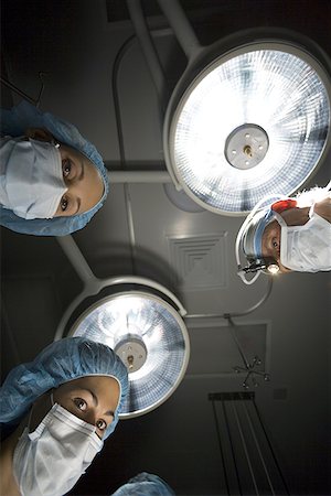 simsearch:640-01364042,k - Low-angle view of three surgeons standing over an operating table Stock Photo - Premium Royalty-Free, Code: 640-01351368