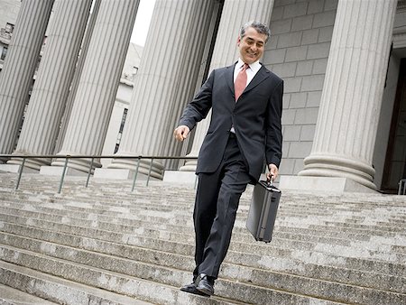 simsearch:640-01350504,k - Low angle view of a male lawyer walking down the steps of a courthouse Foto de stock - Sin royalties Premium, Código: 640-01351408