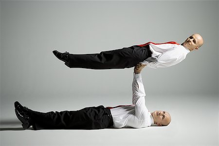 Profile of two male acrobats in business suits performing Stock Photo - Premium Royalty-Free, Code: 640-01351658