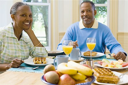 Portrait of a senior man and a senior woman sitting at the breakfast table Stock Photo - Premium Royalty-Free, Code: 640-01351821