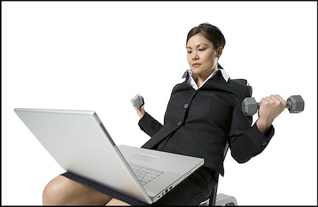 simsearch:640-01351921,k - Businesswoman exercising with dumbbells while working on a laptop Foto de stock - Sin royalties Premium, Código: 640-01351915