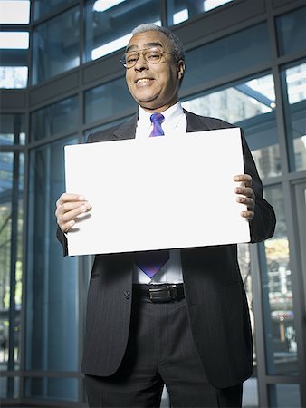 Portrait of a businessman holding a blank sign Stock Photo - Premium Royalty-Free, Code: 640-01352309