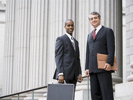 simsearch:640-01351636,k - Low angle view of two men smiling and standing in front of a courthouse Stock Photo - Premium Royalty-Free, Code: 640-01352367