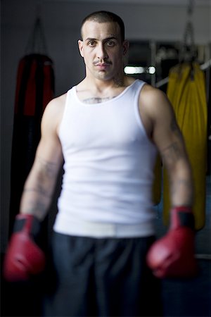 face front man - Portrait of a young man wearing boxing gloves Foto de stock - Sin royalties Premium, Código: 640-01352481