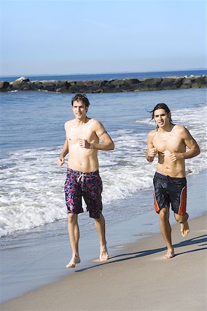 Two young men running on the beach Stock Photo - Premium Royalty-Free, Code: 640-01352968