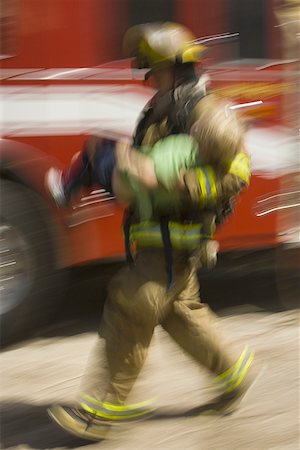 fire truck - Profile of a firefighter carrying a wounded boy Stock Photo - Premium Royalty-Free, Code: 640-01353035