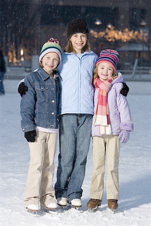 Three girls with skates outdoors in winter smiling Stock Photo - Premium Royalty-Free, Code: 640-01353076