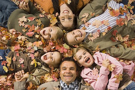 pile leaves playing - Young girls playing in pile of fallen leaves Stock Photo - Premium Royalty-Free, Code: 640-01353098