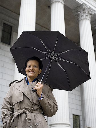 simsearch:640-02767805,k - Low angle view of a woman holding an umbrella and smiling Stock Photo - Premium Royalty-Free, Code: 640-01353222