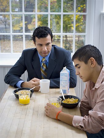 Vue grand angle sur un père assis à une table de petit déjeuner avec son fils Photographie de stock - Premium Libres de Droits, Code: 640-01353268