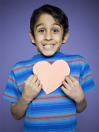 simsearch:640-02767716,k - Portrait of a boy holding a heart shaped paper cutout Stock Photo - Premium Royalty-Free, Code: 640-01353679