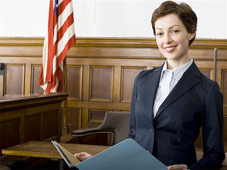 simsearch:640-01350504,k - Portrait of a female lawyer standing in a courtroom and smiling Foto de stock - Sin royalties Premium, Código: 640-01353680