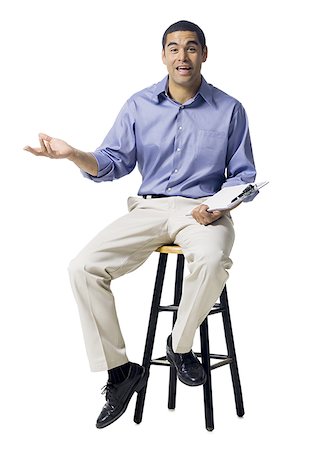 Man sitting on stool with clipboard gesturing Stock Photo - Premium Royalty-Free, Code: 640-01353793