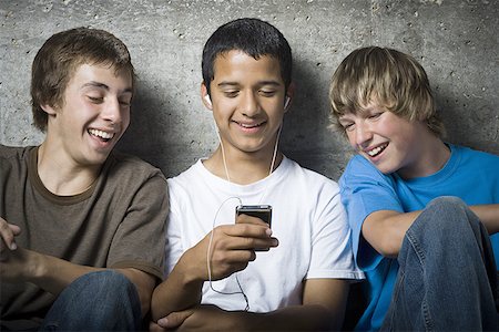 simsearch:640-02767760,k - Gros plan de trois jeunes garçons regardant un lecteur MP3 Photographie de stock - Premium Libres de Droits, Code: 640-01353899