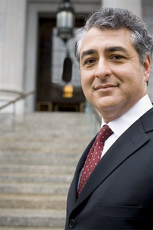 simsearch:640-01351636,k - Portrait of a man standing on the steps of a courthouse and smiling Stock Photo - Premium Royalty-Free, Code: 640-01353892