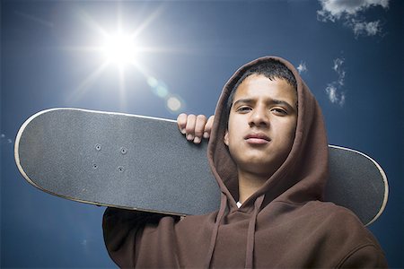 Portrait d'un adolescent portant une planche à roulettes Photographie de stock - Premium Libres de Droits, Code: 640-01353991