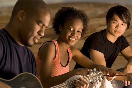 simsearch:640-01350537,k - Profile of a young man sitting with two people and playing a guitar Stock Photo - Premium Royalty-Free, Code: 640-01364245