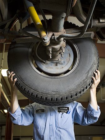 face front man - Mid section view of an auto mechanic fixing a car tire Foto de stock - Sin royalties Premium, Código: 640-01364274