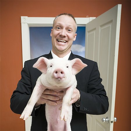 farmyard - Man at home with piglet smiling Stock Photo - Premium Royalty-Free, Code: 640-01364420