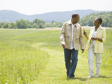 Senior man and a senior woman walking in a field Stock Photo - Premium Royalty-Free, Code: 640-01364450