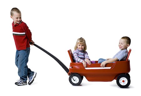 simsearch:400-04847852,k - Profile of a boy pulling a boy and a girl in a toy wagon Stock Photo - Premium Royalty-Free, Code: 640-01364452